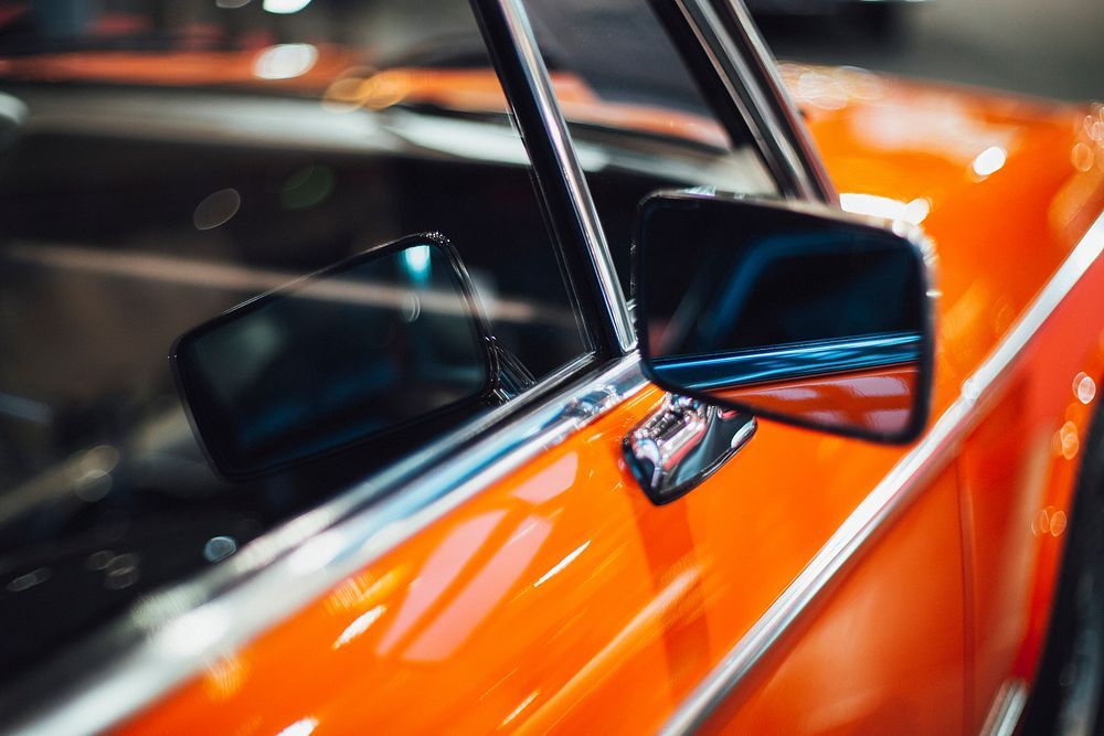 Close up of an orange car wing mirror