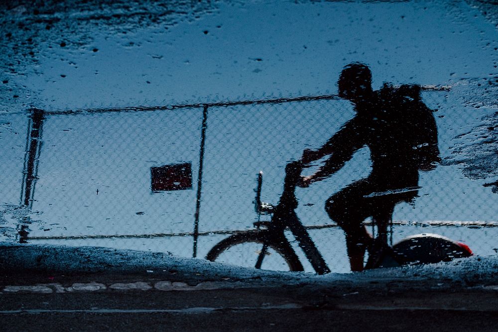 Reflection of a cyclist in a puddle