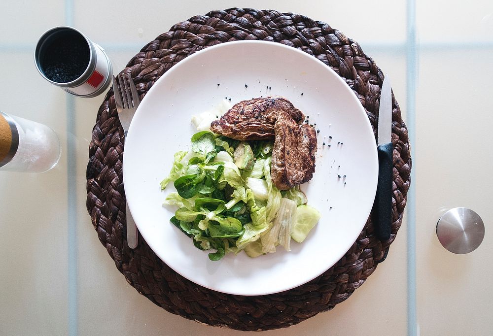 beef steak with green salad on table