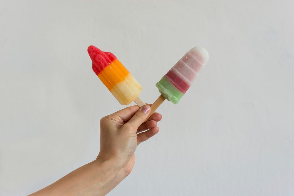 Hand holding two popsicles