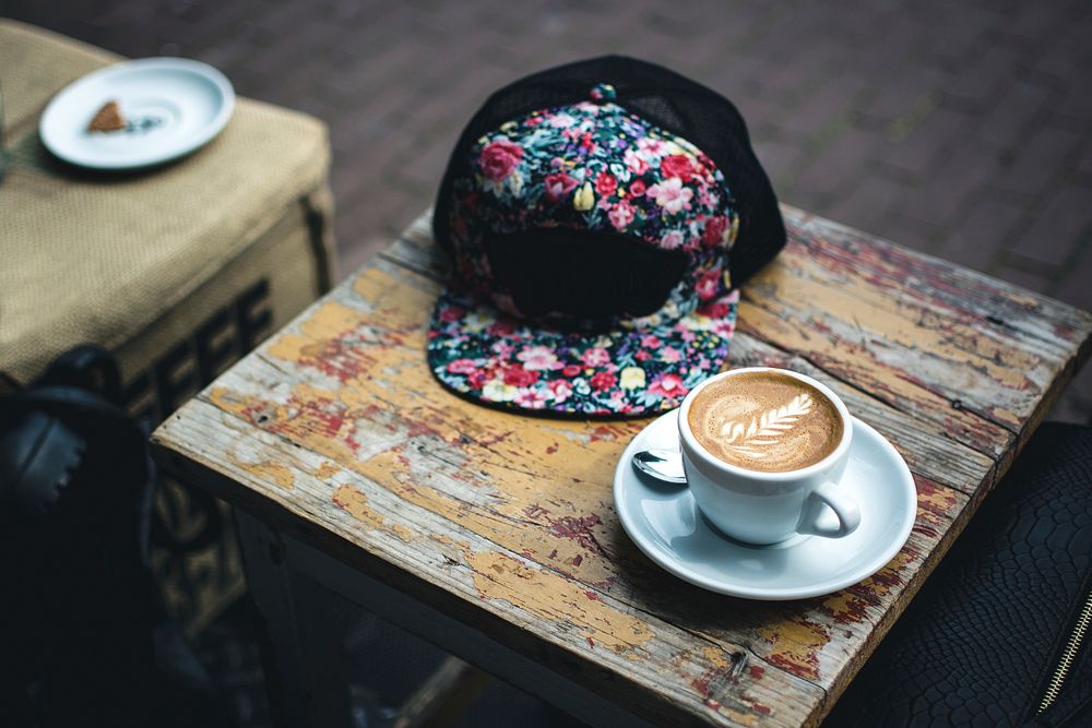 A cup of coffee and a cap