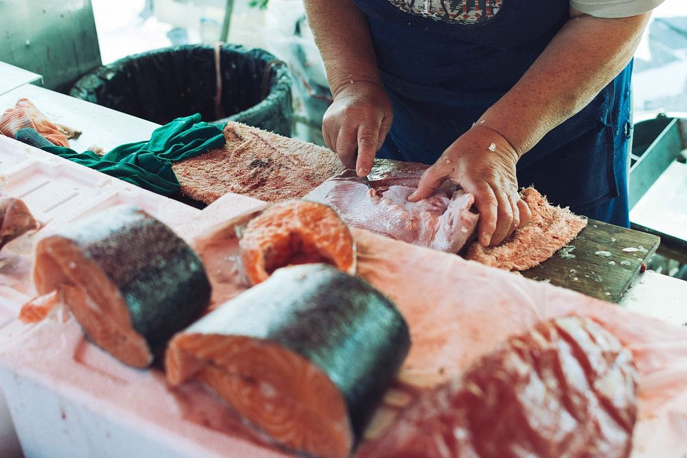 Seller slicing fish fillet