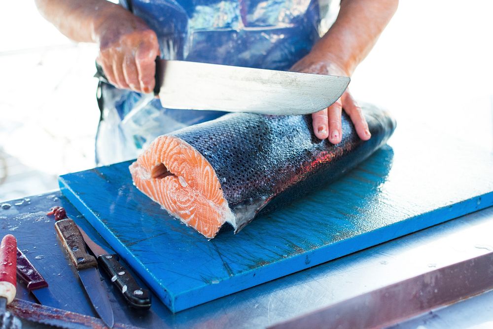 Fresh salmon being sliced at a market