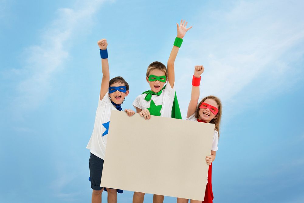 Smiling superhero kids holding an empty placard