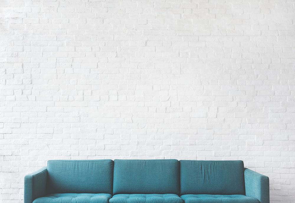 Teal couch on a mockup brick wall