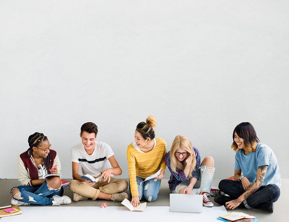 Group of diverse teens doing their project on the floor