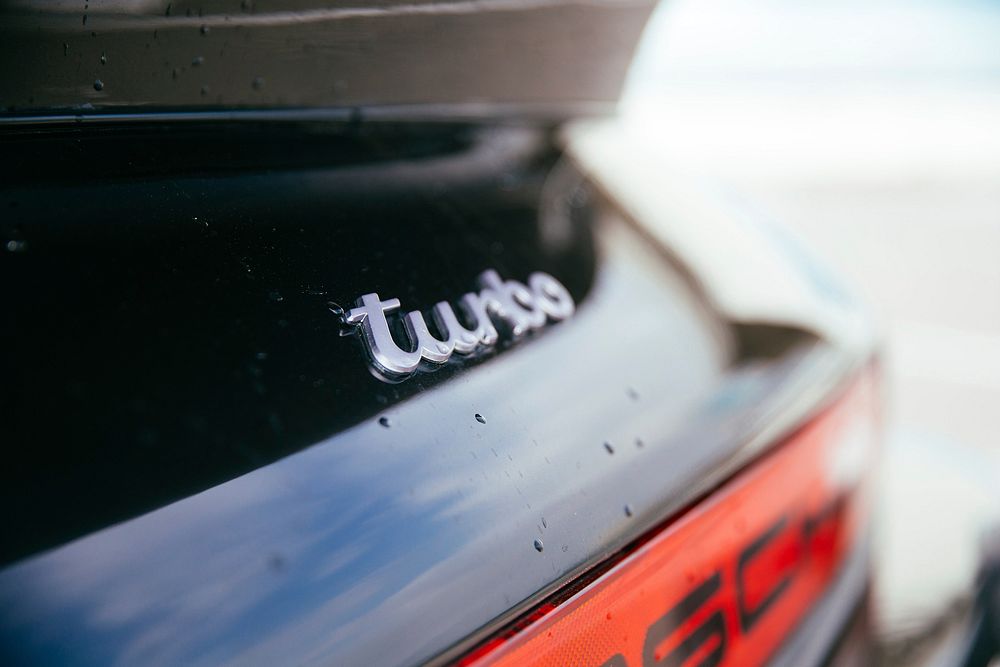 Turbo badge on a vintage black German sports car.