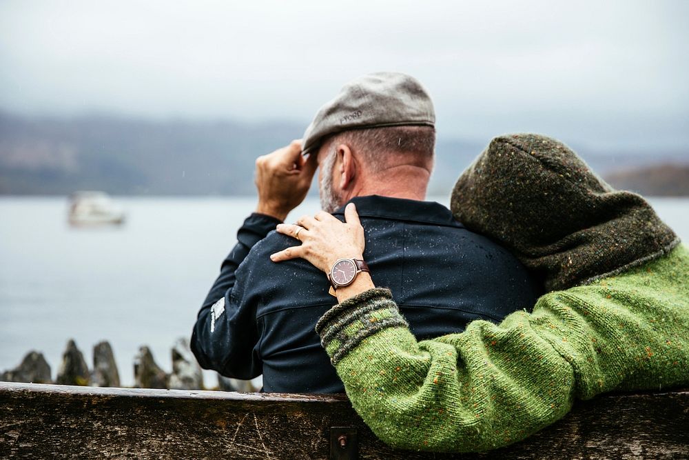 Free couple sitting on a bench looking out over the water image, public domain CC0 photo.