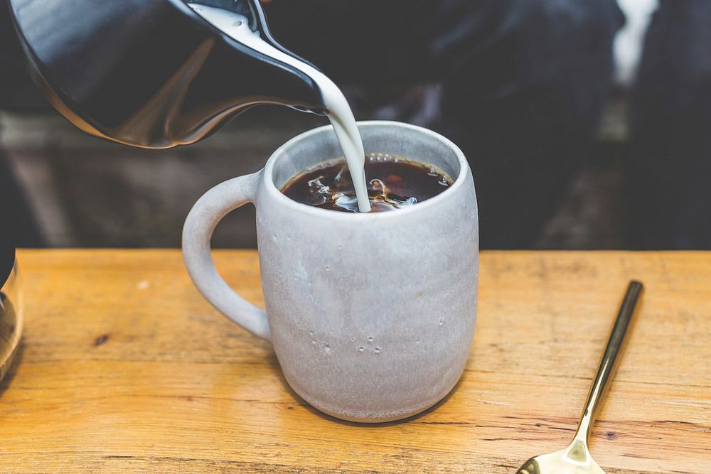 Free milk pouring into coffee mug photo, public domain beverage CC0 image.