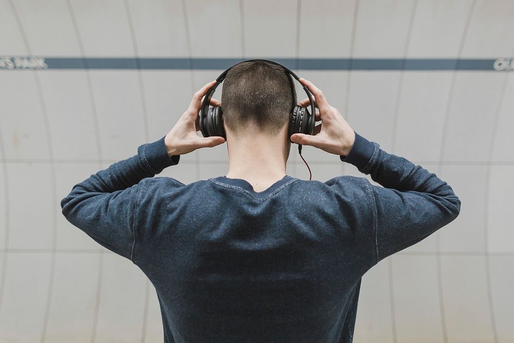 Man holding headphones on head.