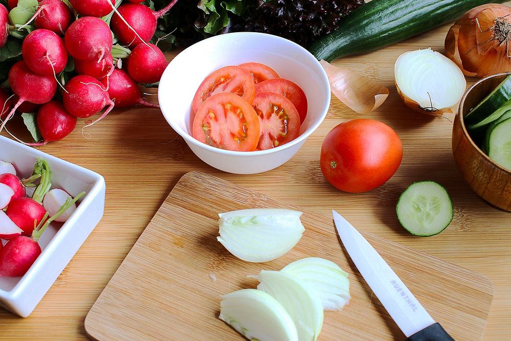 Free sliced tomato, onion, radish, chopping board photo. Free vegetables public domain CC0 image.