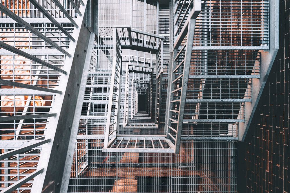 Looking down through the center of a tall fire escape, free public domain CC0 image.