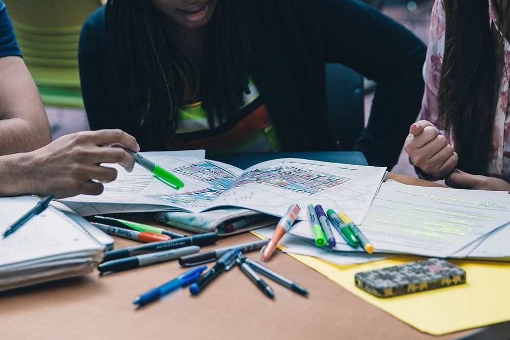 Close up of a study group with notebooks and markers on the table, free public domain CC0 photo.