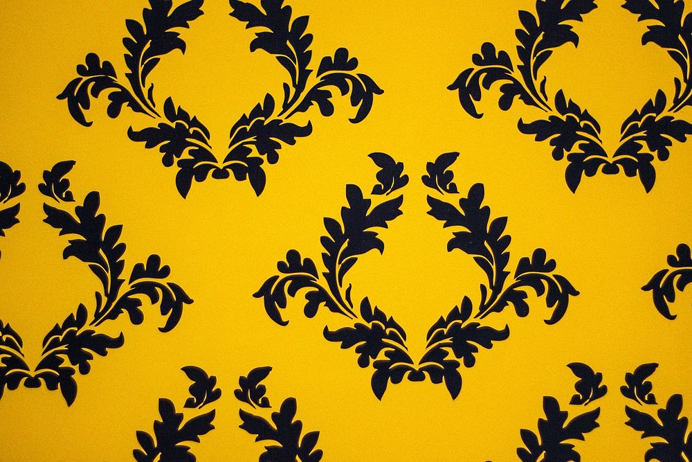 Yellow background with black filigree pattern.
