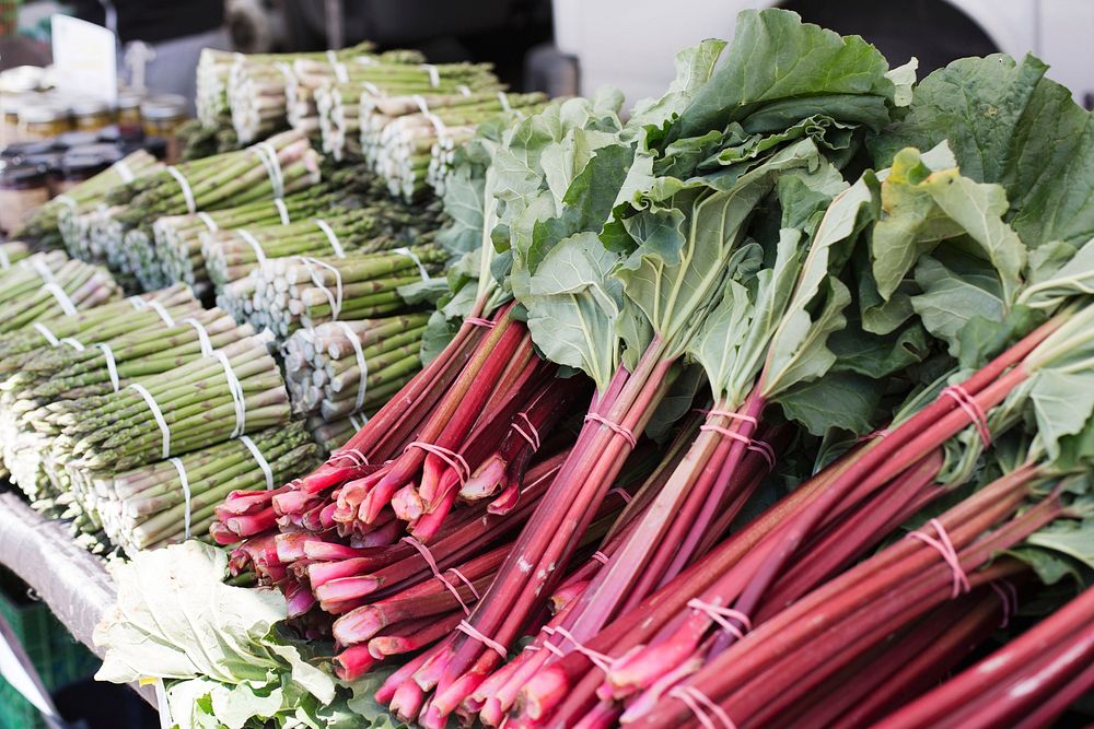 Free piles of asparagus and rhubarb on a market table photo, public domain CC0 image.