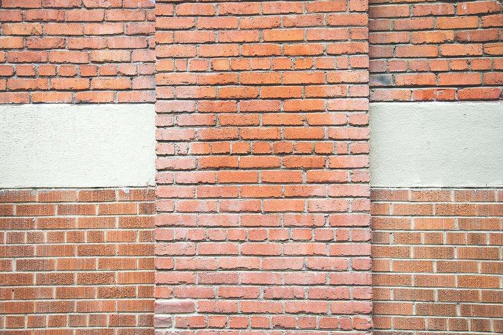 Brick wall background with older and newer brick and horizontal layer of white cement.