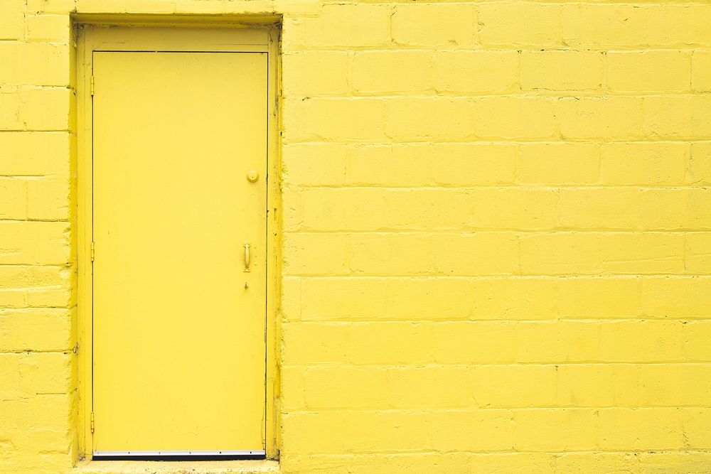 Brght yellow door and brick wall, free public domain CC0 image.