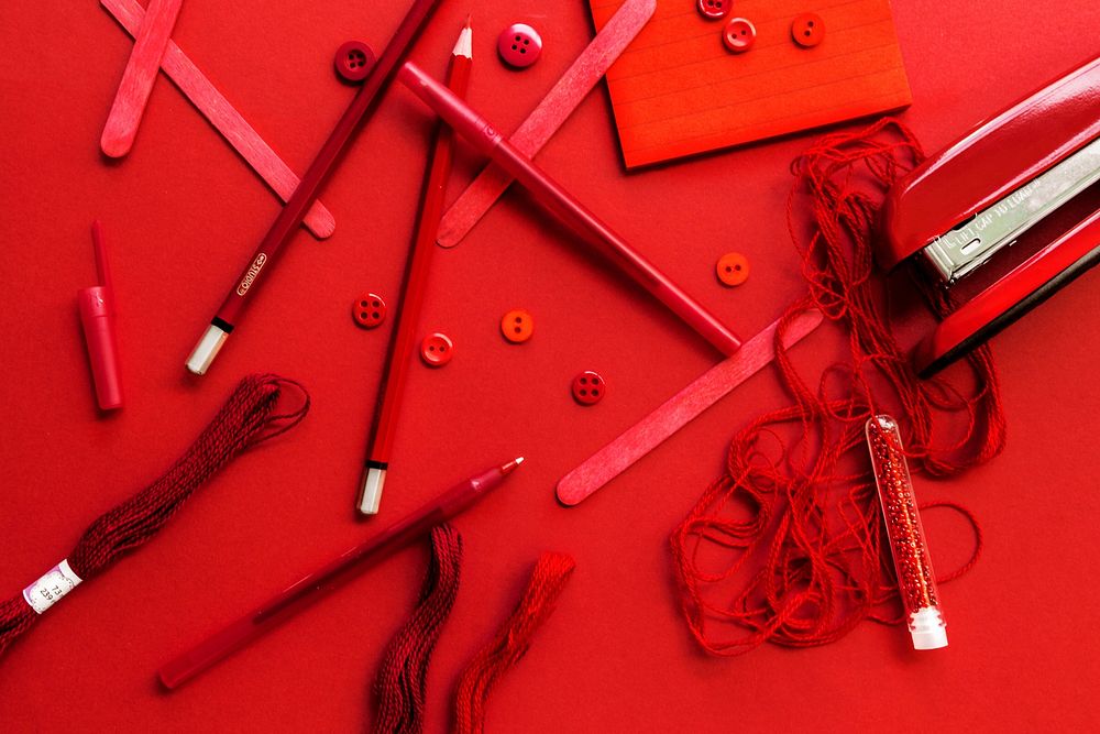 An assortment of red art supplies in a creative flatlay.