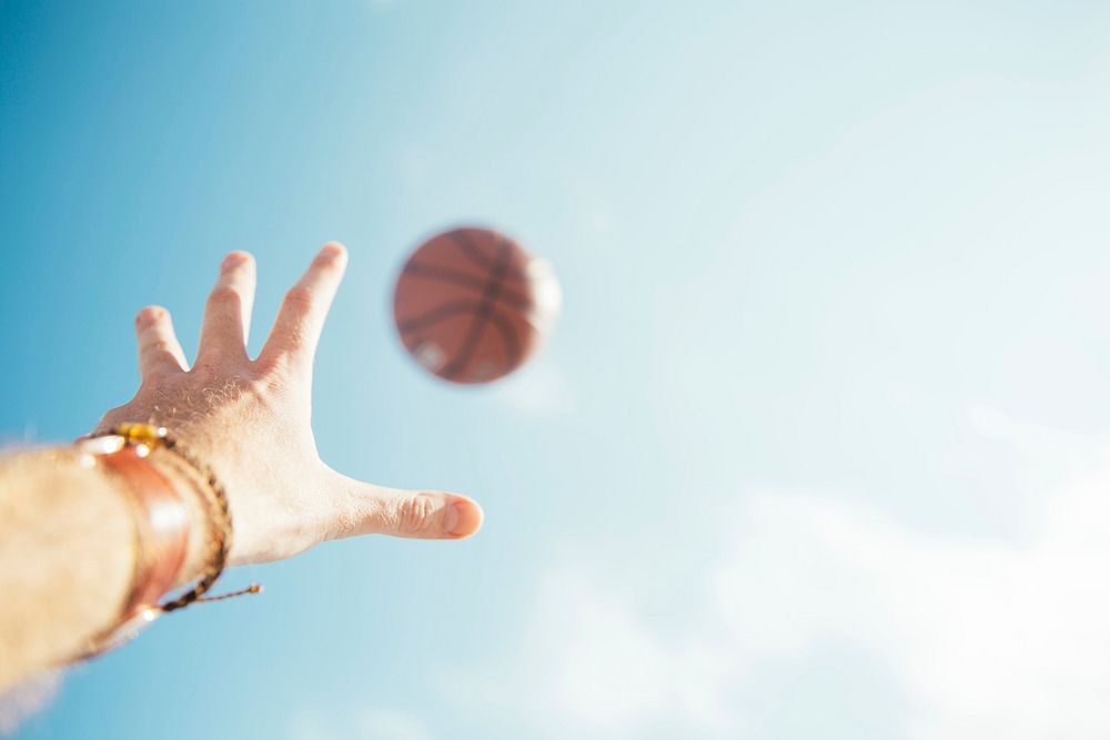 Free man throwing basketball in air photo, public domain sport CC0 image.