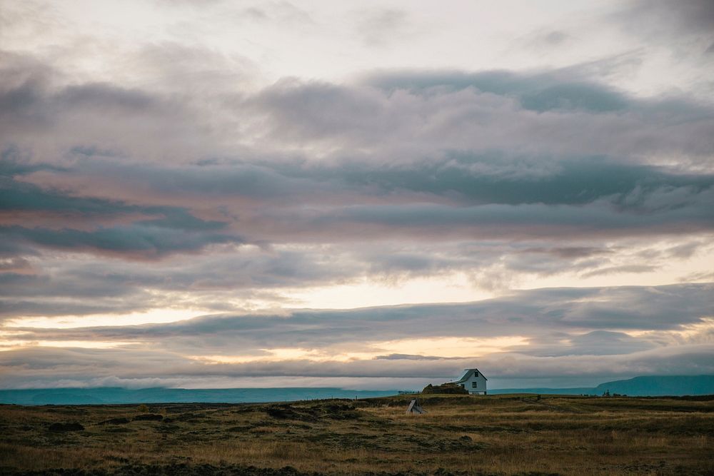 A lone house in the middle of the Iceland fields. Iceland at sundown.