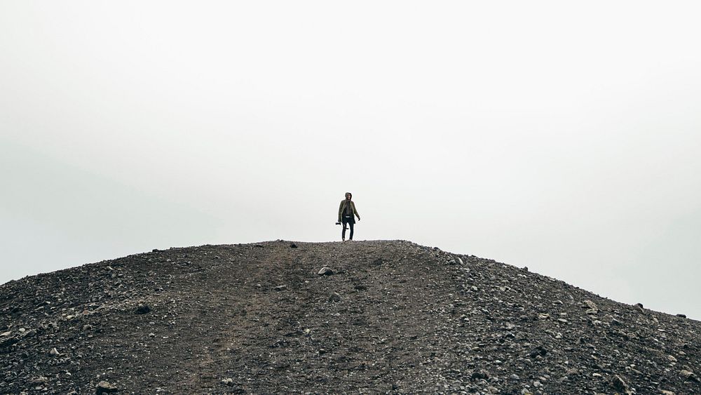 Standing on a high, black gravel hill. Admiring all the scenery offers in Iceland.