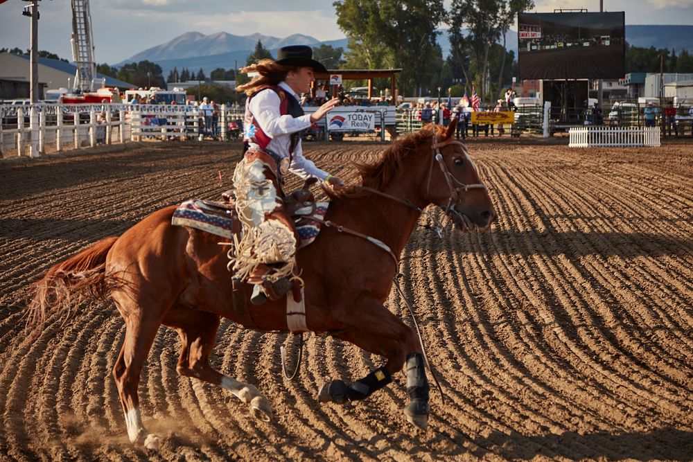 A contestant puts her ride through its paces at the Cattlemen's Days rodeo in Gunnison, Colorado. Original image from Carol…