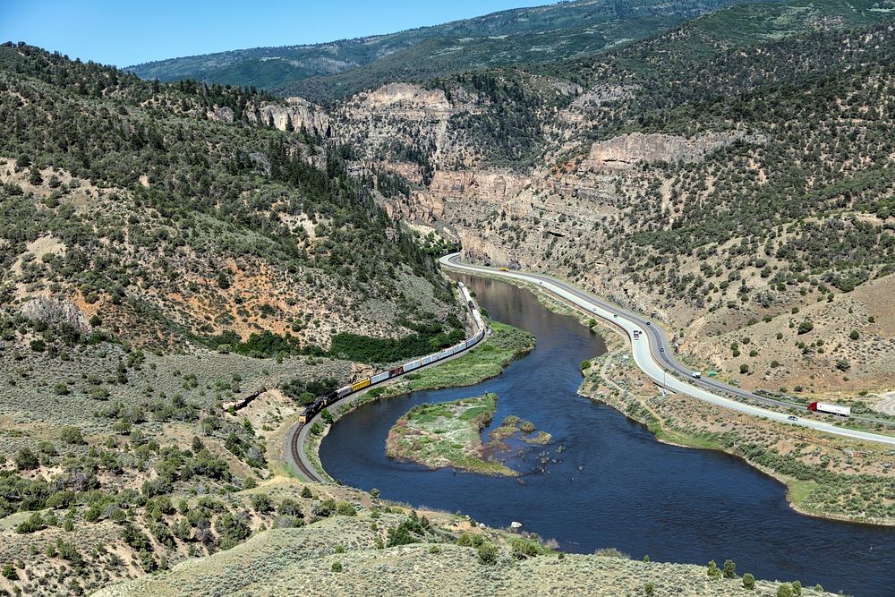 A train exits the winding Glenwood Canyon on the Colorado River, heading east from Glenwood Springs, Colorado. Original…