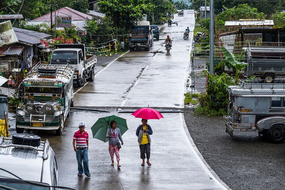 People walking in he rain in a small village, Nueva Vizcaya, Philippines, July 2017.