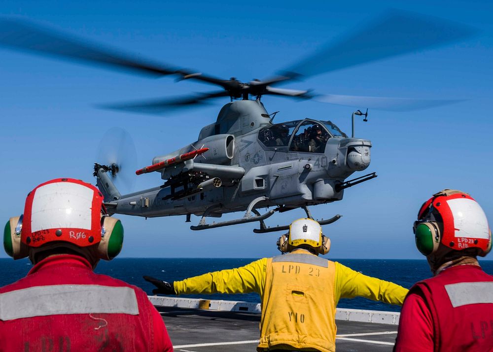 U.S. Sailors assigned to the San Antonio-class amphibious transport dock USS Anchorage (LPD 23), signal an AH–1Z Viper…