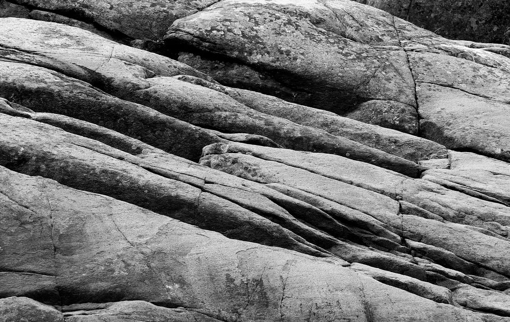 Red granite cliffs with lichen in Govik bw