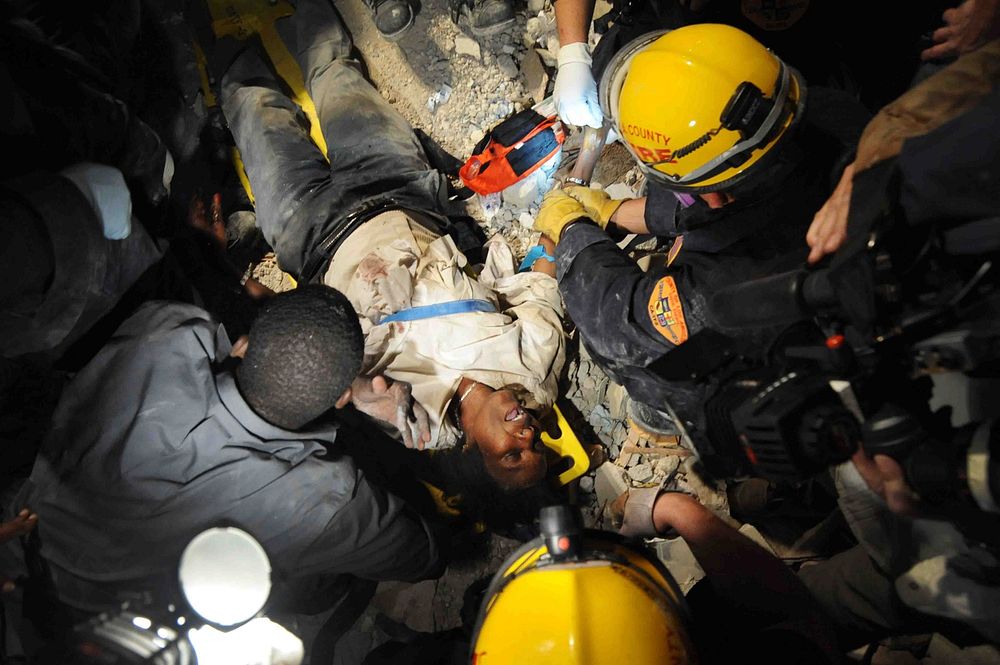 Members of the Los Angeles County Fire Department Search and Rescue Team rescue a Haitian woman from a collapsed building in…