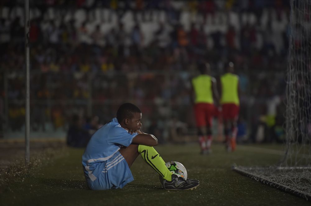 A ball boy sits behind the goal net in the finals of the Mogadishu District Football Tournament between the Waaberi and…