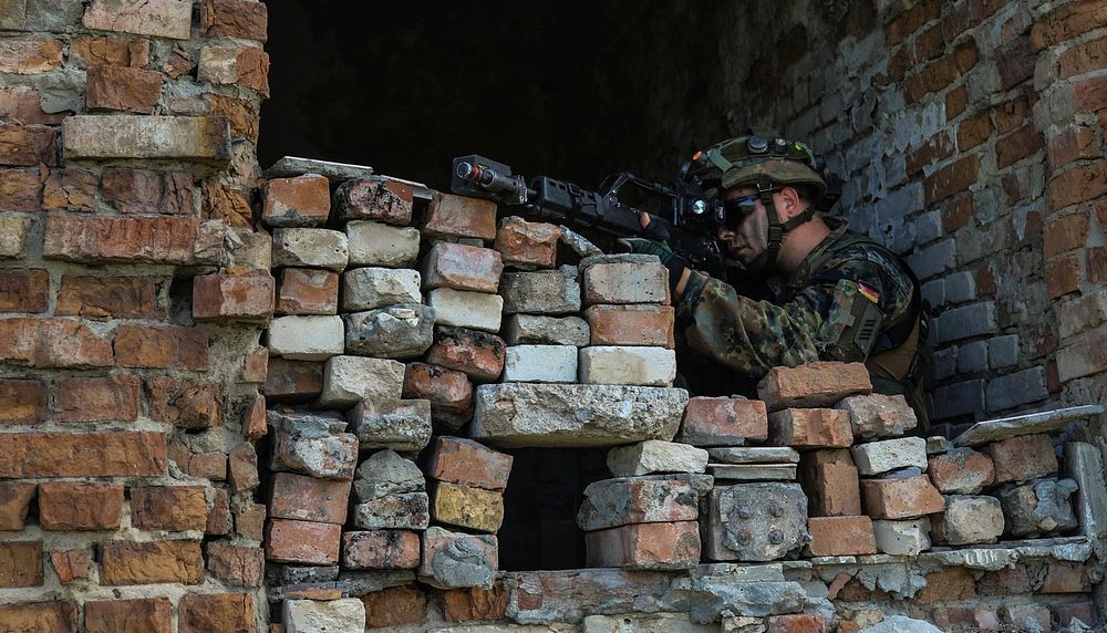 A German army infantryman with the 391st Mechanized Infantry Battalion pulls security in a recently secured building at…