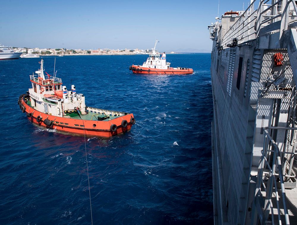 RHODES, Greece (Aug. 14, 2018) Greek tugboats, guide the Spearhead-class expeditionary fast transport ship USNS Carson City…
