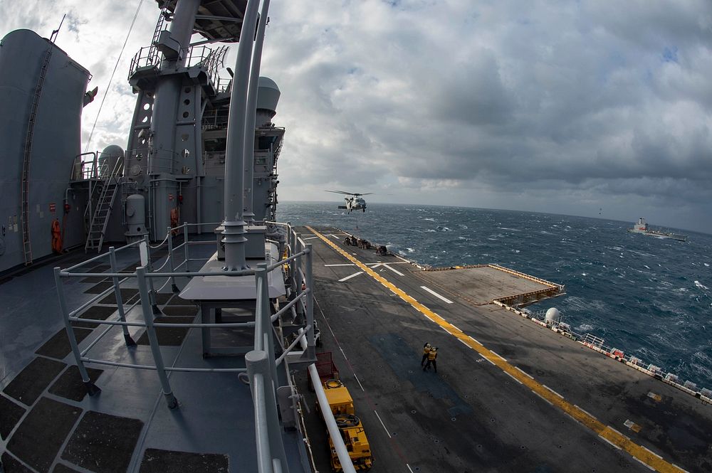A U.S. Navy MH-60S Sea Hawk helicopter, attached to Helicopter Sea Combat Squadron (HSC) 22, drops off supplies on the…
