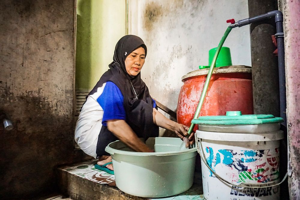 Muslim woman cleaning. Tinggal Ngulir Kran-Cuuurr-Air e Ngalir.