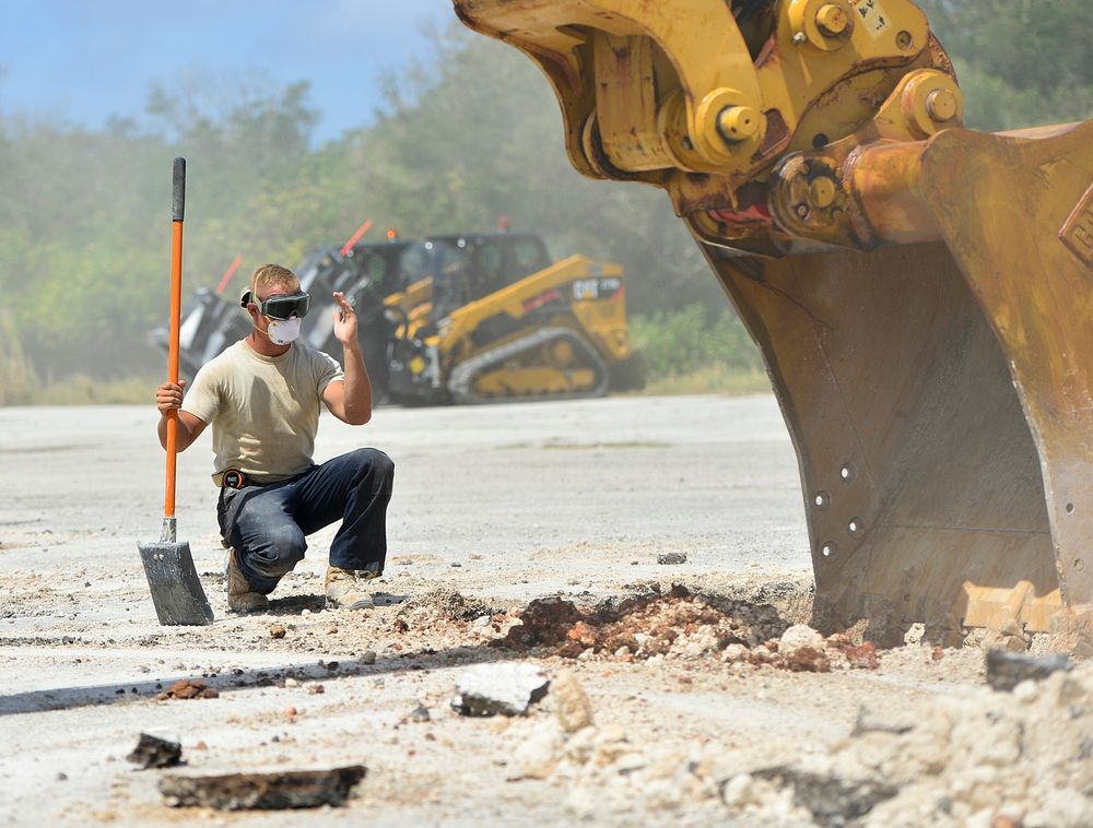 A U.S. Airman assigned to the 36th Civil Engineer Squadron directs an excavator while repairing a damaged airfield during…