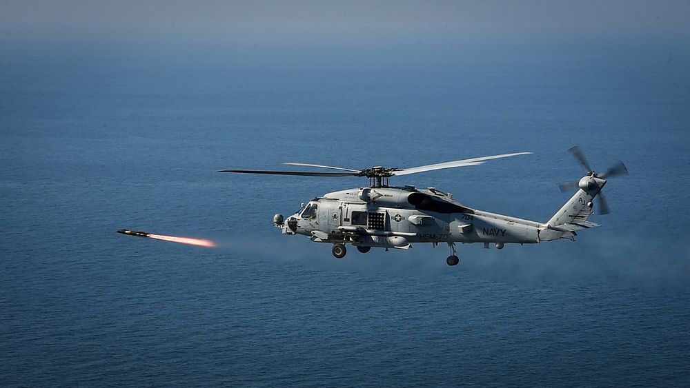 A U.S. Navy MH-60R Seahawk helicopter assigned to the "Spartans" of Helicopter Maritime Strike Squadron (HSM) 70 shoots an…