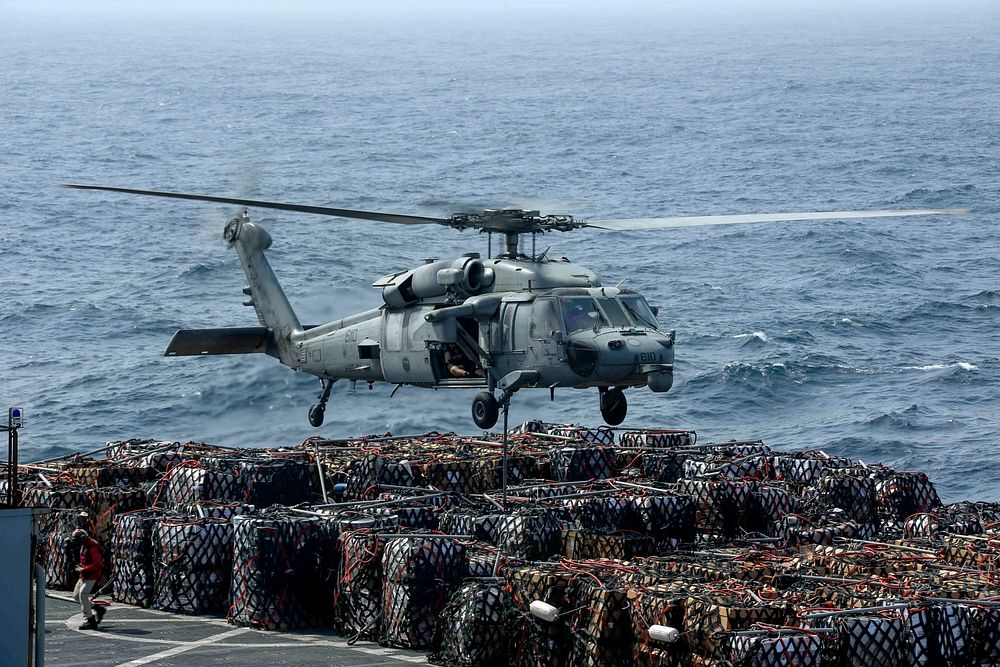 A U.S. Navy MH-60S Sea Hawk helicopter from the Nightdippers of Helicopter Sea Combat Squadron (HSC) 5 transports cargo from…