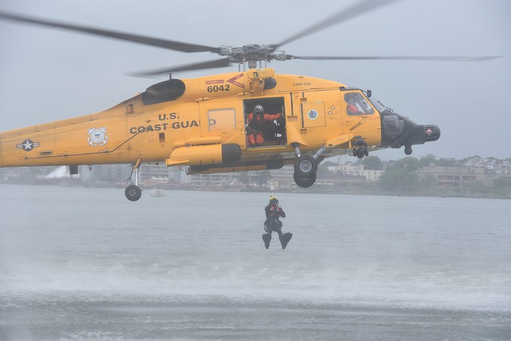 A U.S. Navy rescue swimmer from Air Station Cape Cod drops into the water from an MH-60 Jayhawk during a SAR demonstration…