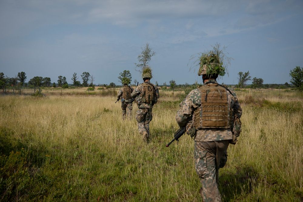 Latvian Soldiers from the Latvian National Guard’s 2nd Brigade, 25th Infantry Battalion patrol through a training area at…