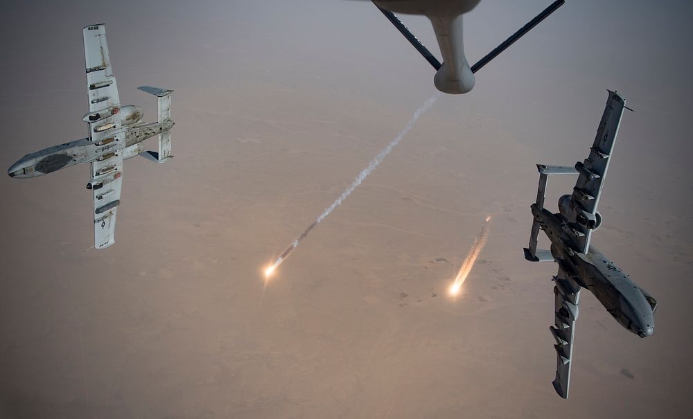 U.S. Air Force A-10 Thunderbolt IIs fire flares while breaking away after aerial refueling from a KC-135 Stratotanker…