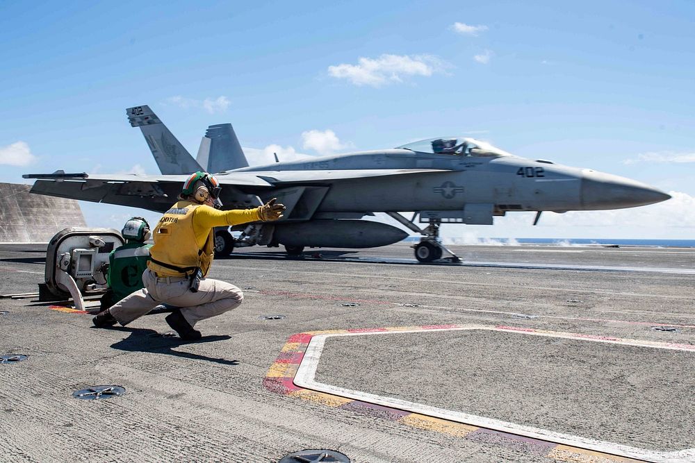 U.S. Navy Lt. Kristin Hope, from Ogden, Utah, signals to launch an F/A-18E Super Hornet from Strike Fighter Squadron (VFA)…