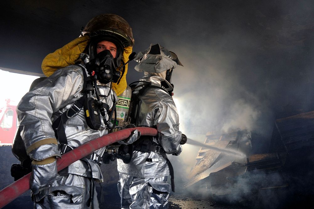 Fire fighters from the 447th Expeditionary Civil Engineer Squadron extinguish a fire in a training room during live-burn…