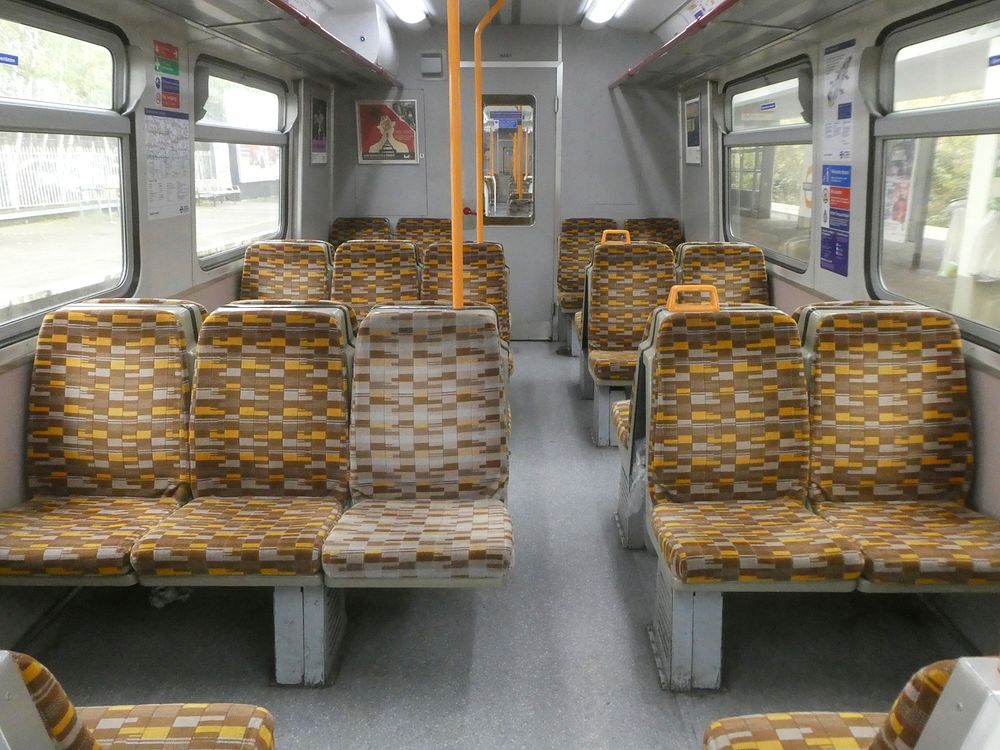 Inside British Rail Class 315 train with London Overground seat fabric.