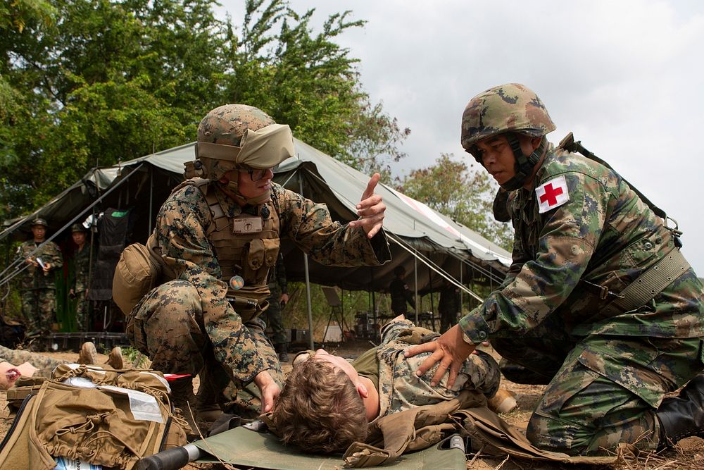 U.S. Navy Petty Officer 3rd Class John Henry aids a Royal Thai sailor with a simulated casualty while participating in a…