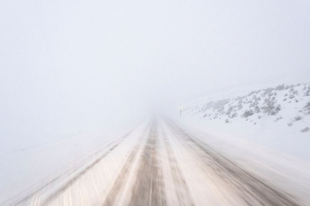 Whiteout conditions on park road. Original public domain image from Flickr