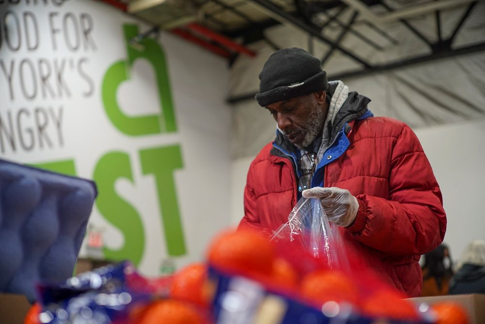 Volenteers at the City Harvest warehouse in Long Island City, Queens, NY help pack shelf-stable items into individual bags…