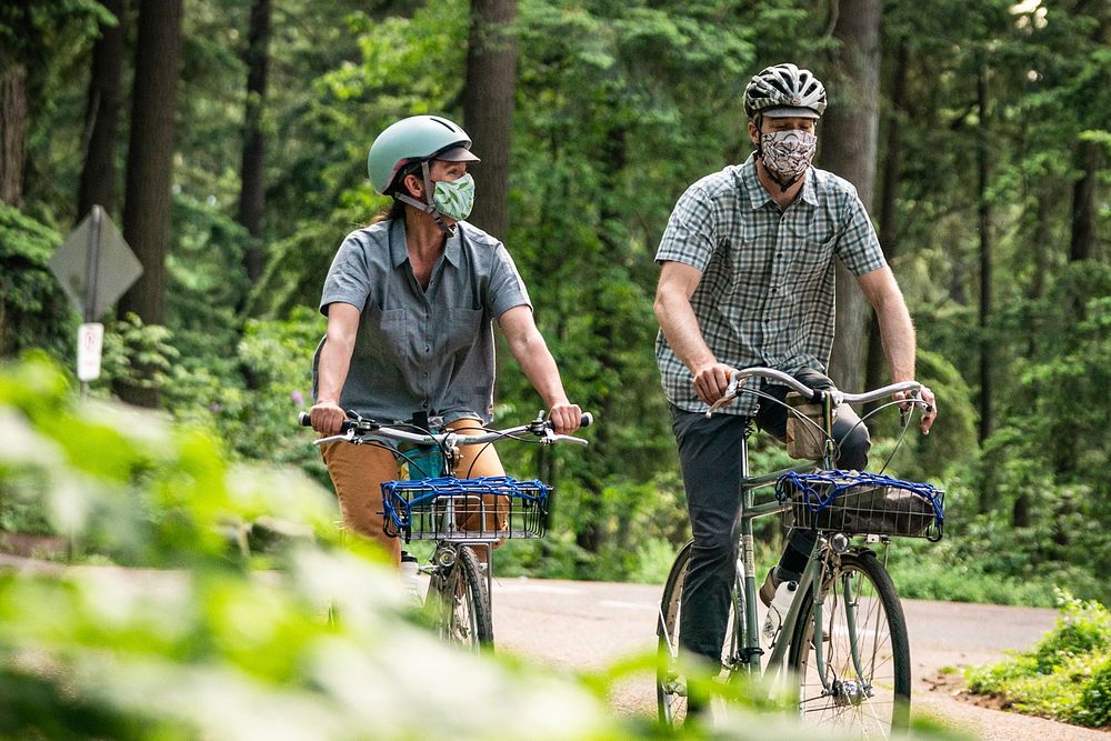 Couple cycling in the outdoors with face coverings, Oregon. Original public domain image from Flickr