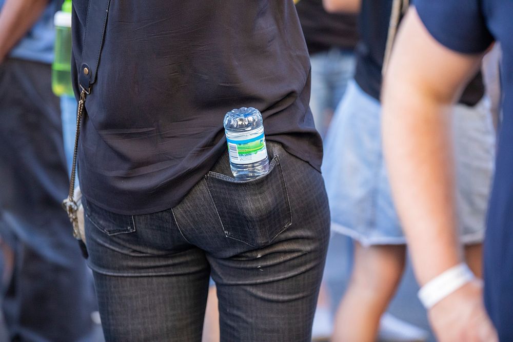 Woman with water bottle in pocket. Free public domain CC0 photo.